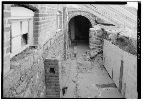 Fouille le long d'un mur de cave ancien dégagé pour poser un système de drainage
